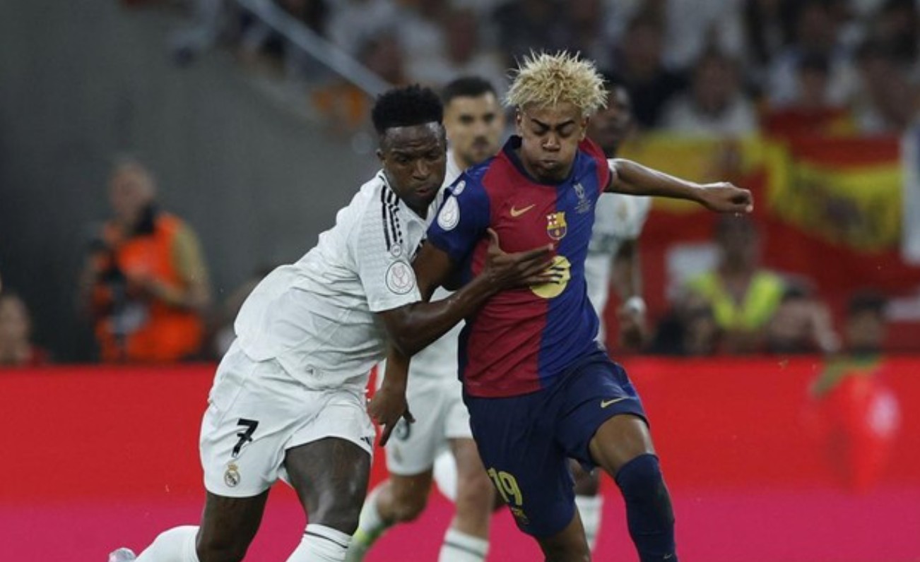 Aksi VInicius Jr dan Lamine Yamal dalam El Clasico antara Real Madrid dan Barcelona musim lalu.