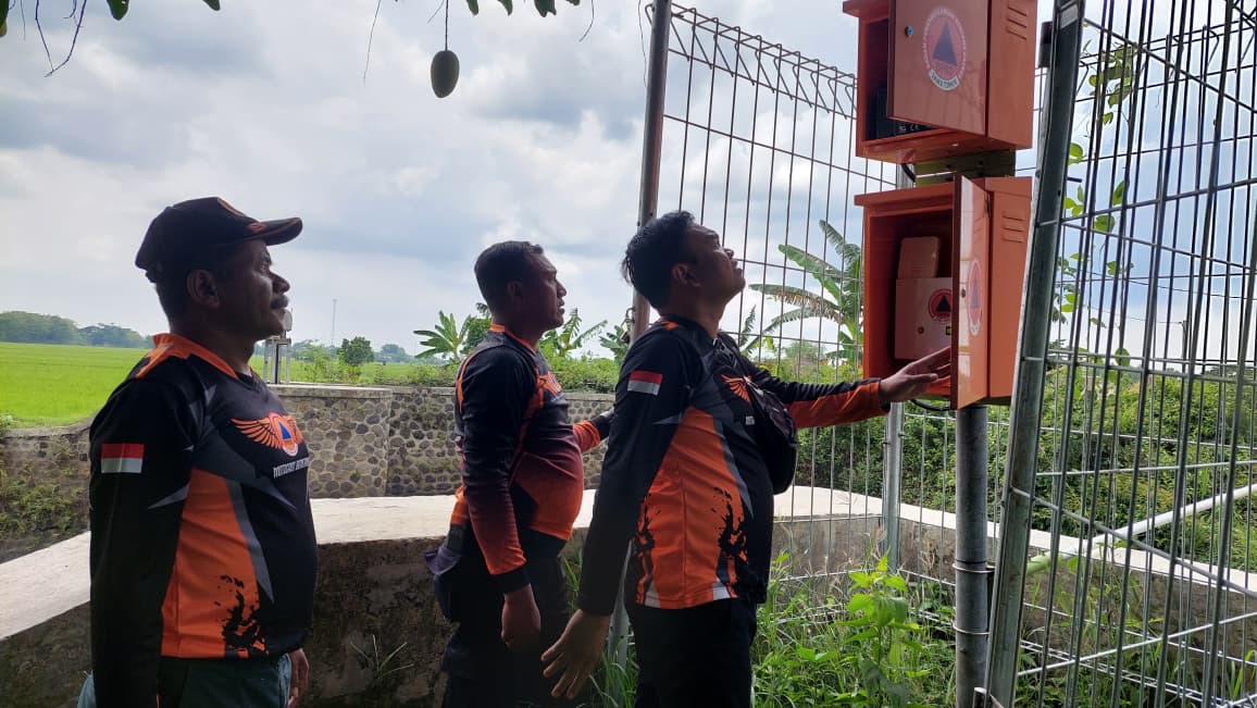Petugas BPBD Kabupaten Madiun mengecek kondisi EWS di Desa Sumberejo, Kecamatan Madiun, untuk memastikan alat peringatan dini bencana berfungsi optimal. DIAN RAHAYU/RADAR MADIUN