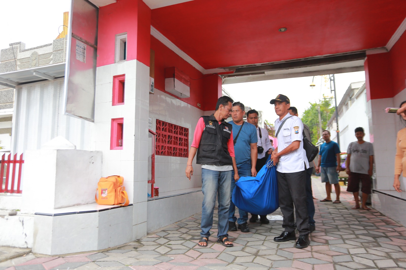 Polisi mengevakuasi seorang kakek yang ditemukan meninggal dunia saat mengantar pesanan bebek di Gang Merah Putih, Selasa (28/10). FOTO: BAGAS BIMANTARA/RADAR MADIUN
