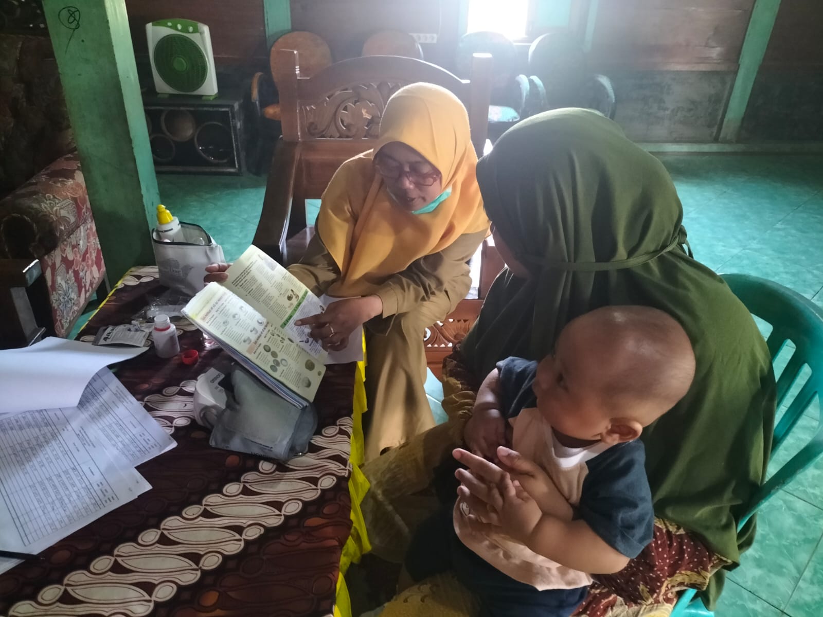 EDUKASI: Bidan desa memberikan edukasi kesehatan kepada pasien saat kegiatan Poyandu Durian Desa Sumberejo.