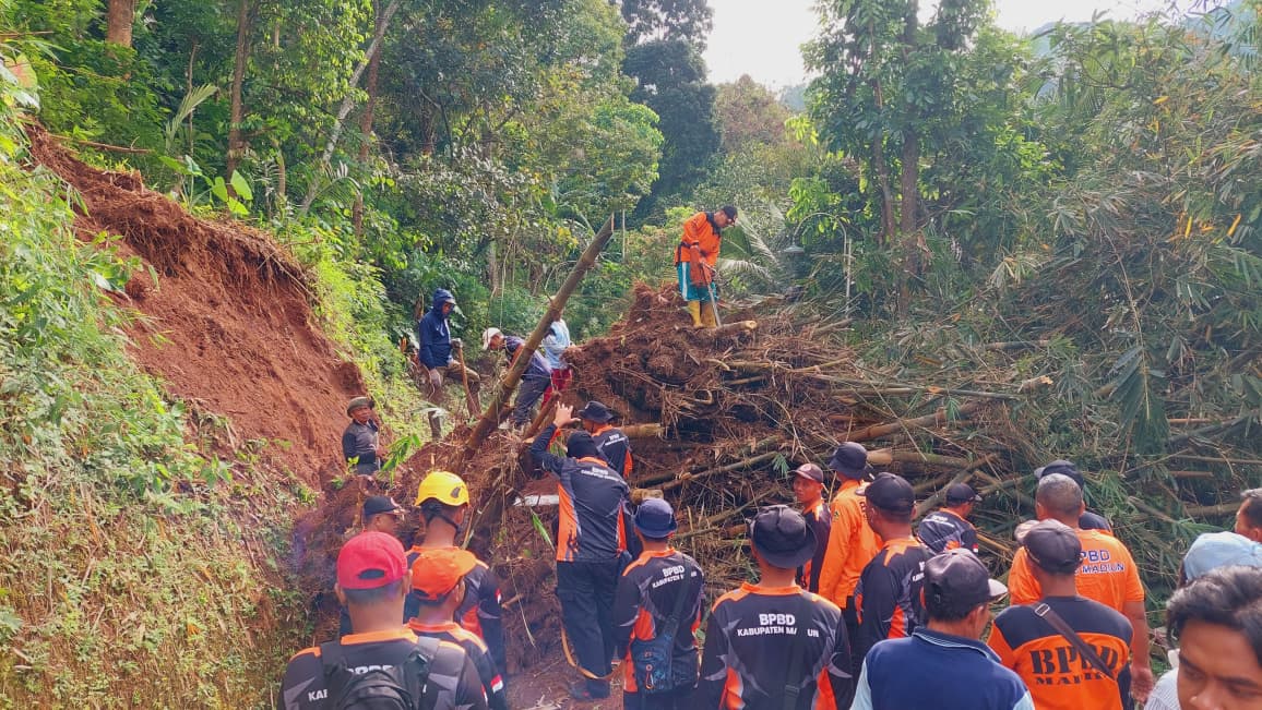 Warga bersama relawan BPBD dan TNI/Polri membersihkan material longsor yang menutup jalan alternatif di Dusun Tegir, Desa Padas, Kecamatan Dagangan, Rabu (29/10). DIAN RAHAYU/RADAR MADIUN