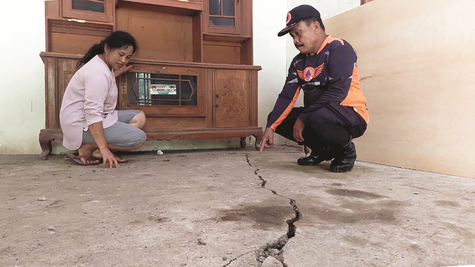 Warga Dusun Morosowo, Dagangan, Madiun memeriksa rumah mereka yang rusak akibat tanah retak. DIAN RAHAYU/RADAR MADIUN