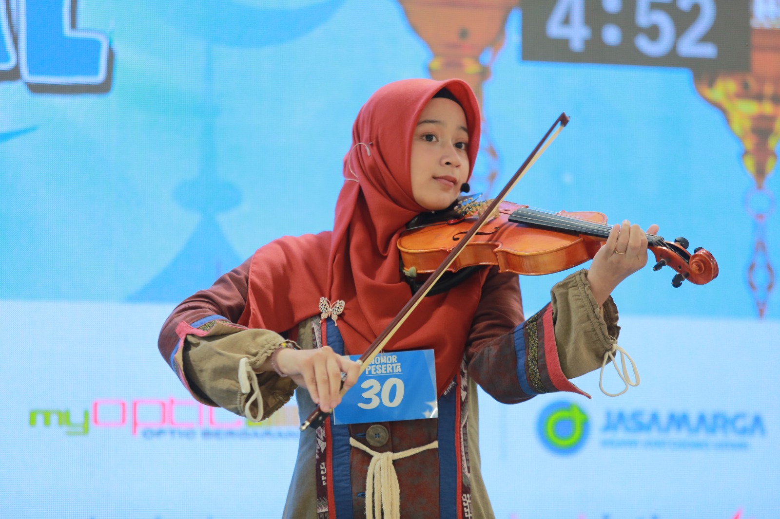 Senandung Langit Jingga, siswi MTsN 1 Madiun, tampil memukau dengan dakwah dan lantunan biola hingga meraih Juara II Festival Dai Cilik Jawa Pos Radar Madiun 2025. BAGAS BIMANTARA/RADAR MADIUN