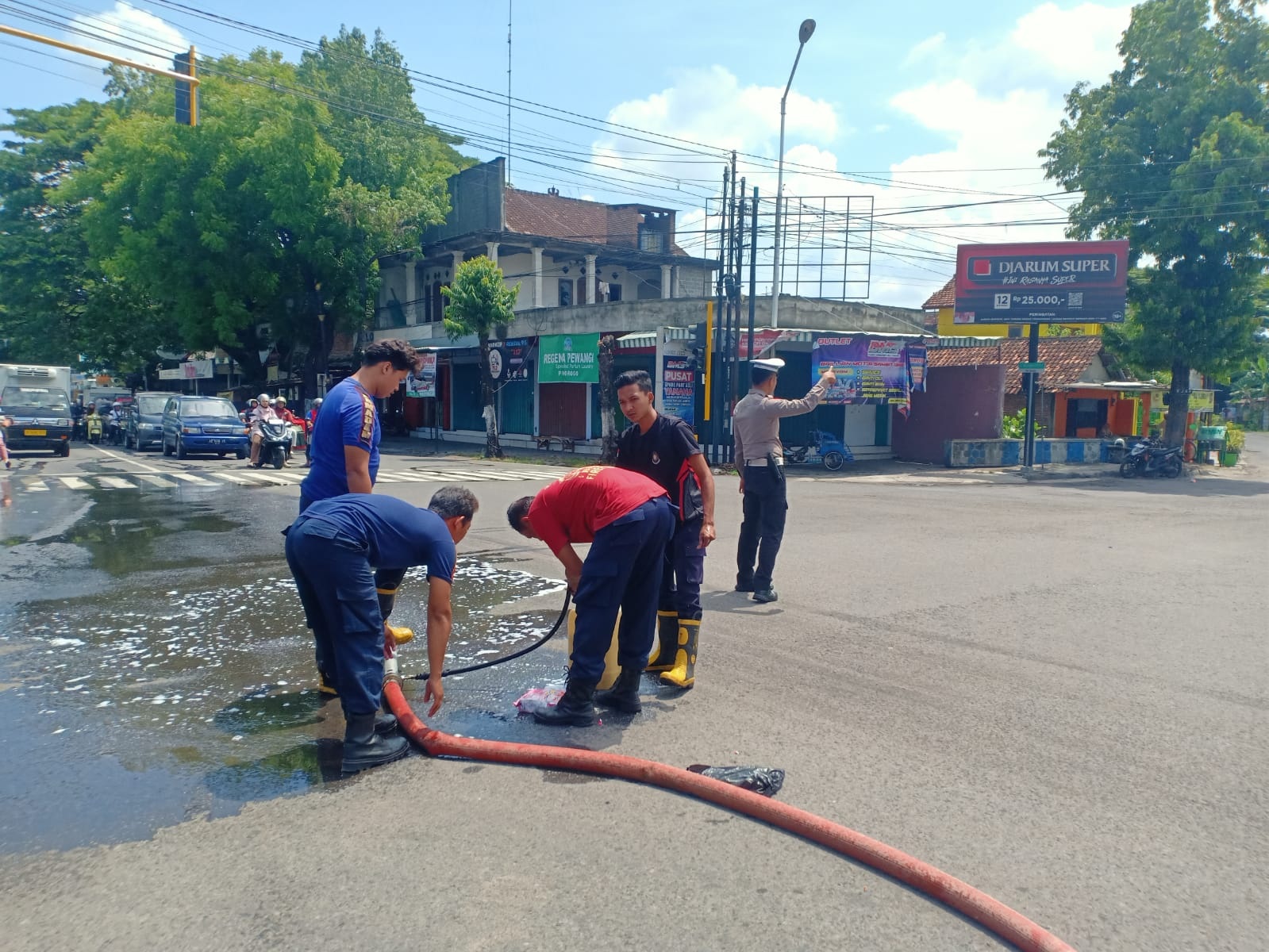 Petugas Damkar Ponorogo menyemprot jalan di kawasan Arief Rahman Hakim untuk membersihkan tumpahan solar yang menyebabkan pengendara terpeleset, Senin (3/11). FOTO: SUGENG DWI N/RADAR PONOROGO