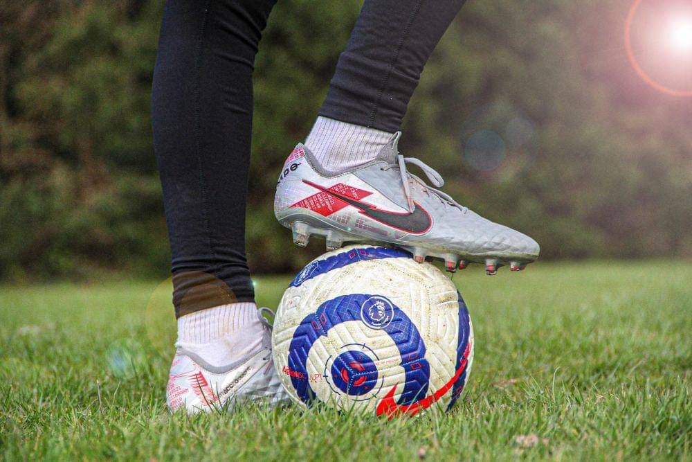 Tips memilih sepatu sepak bola untuk lapangan rumput asli dan lapangan sintetis.