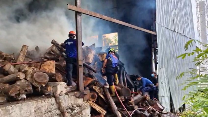 Petugas damkar Ponorogo berupaya memadamkan api di bawah tumpukan kayu setinggi sepuluh meter di pabrik tepung Desa Tajug, Siman, Kamis (6/11). SUGENG DWI N/RADAR PONOROGO
