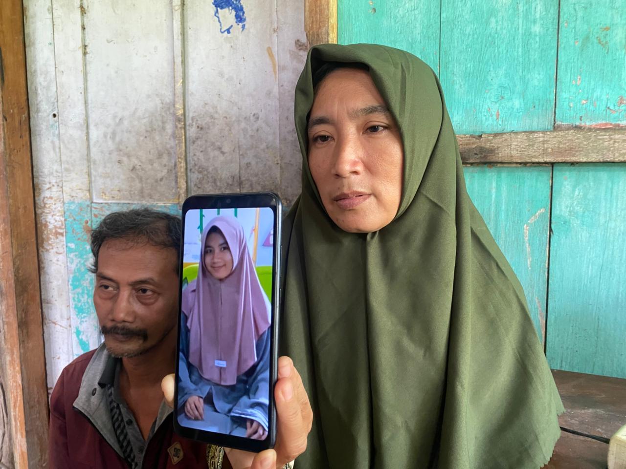 Linda Purwati menunjukkan foto putrinya, Renanda Maharani Kharisma, yang hilang sejak 3 November lalu. FOTO: ERLITA HERMININGSIH / JAWA POS RADAR MADIUN