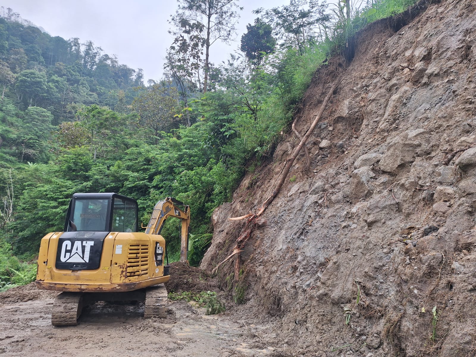 BPBD dan warga mengevakuasi material longsor yang menutup akses jalan di wilayah Poncol. AJI PUTRA/RADAR MAGETAN