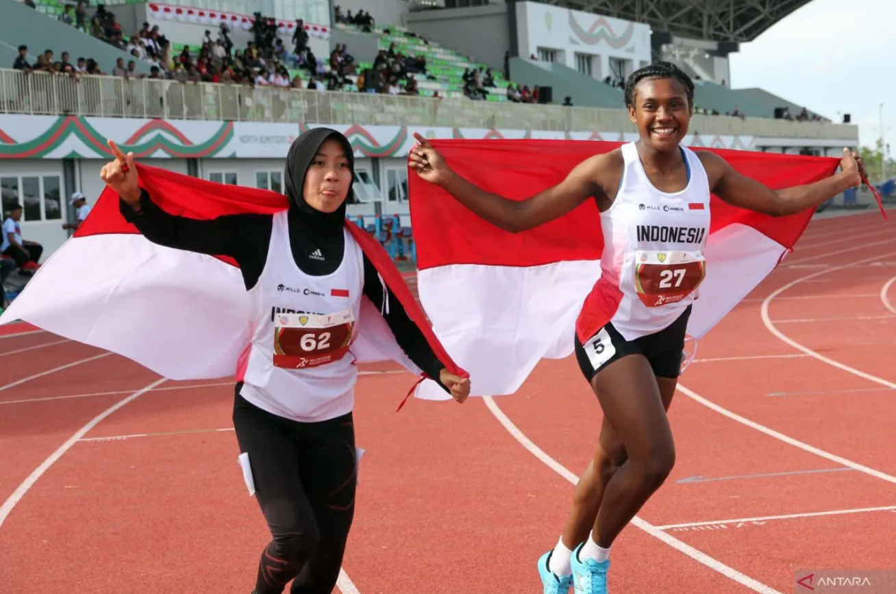 Shava Warangga (kiri) bersama Danselina Tauru (kanan) selebrasi usai juara pada nomor lari 100 meter dalam Kejuaraan Atletik Asia Tenggara 2025 di Stadion Madya Atletik, Deli Serdang, Minggu (16/11).