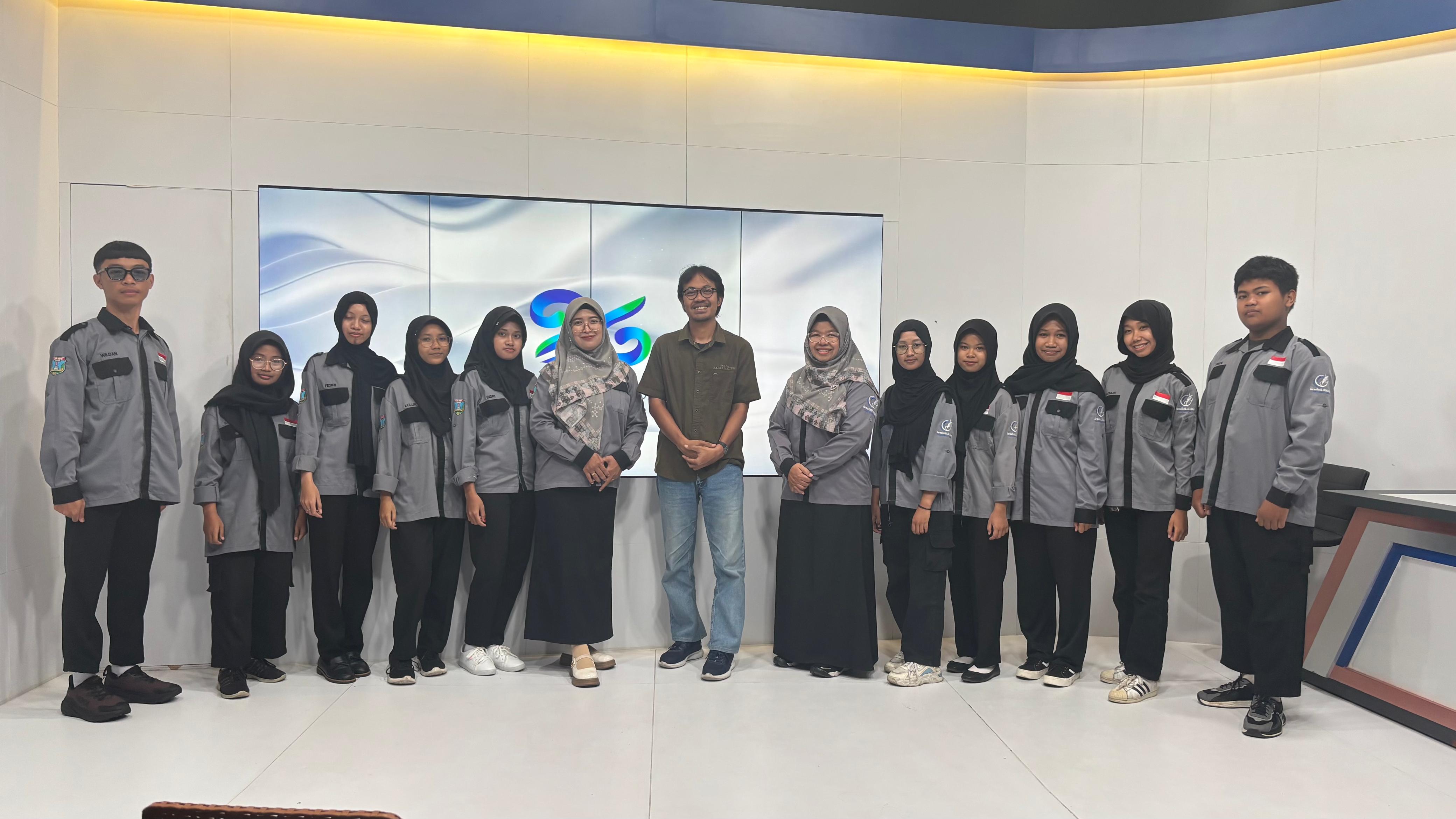 Guru dan siswa dari Ekstrakurikuler Jurnalistik SMKN 2 Magetan berfoto bersama usai diklat di Studio JawaPos TV Madiun, Senin 17 November 2025.