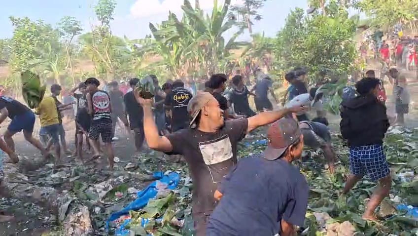 SALING LEMPAR: Warga Desa Plang Lor, Kecamatan Kedunggalar, saat perang nasi dalam peringatan bersih desa beberapa waktu lalu.