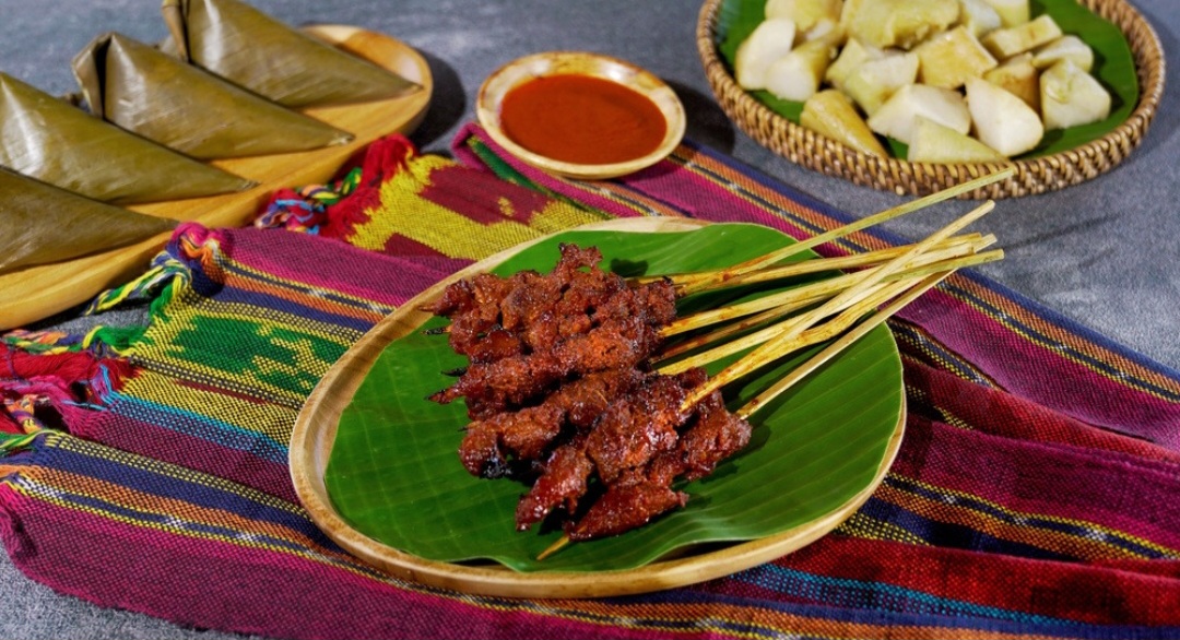 Sate Bulayak, sate ayam atau sapi yang disajikan dengan lontong spiral bulayak dari daun aren.