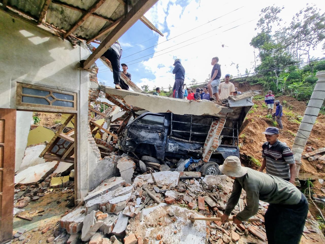 Petugas BPBD mengevakuasi material longsor yang menimbun rumah warga dan menutup akses delapan RT di Desa Wagir Kidul, Pulung. FOTO: SUGENG DWI N/JAWA POS RADAR PONOROGO