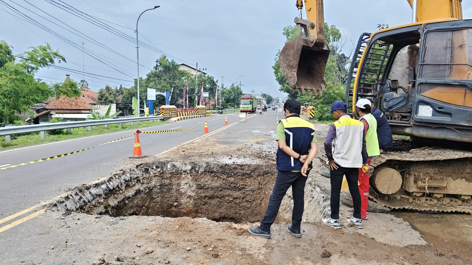 Petugas DPU Bina Marga memperbaiki lubang raksasa di Jalan Raya Ponorogo&ndash;Madiun, Babadan, untuk mencegah kecelakaan akibat amblesnya struktur drainase lama. SUGENG DWI N/RADAR PONOROGO