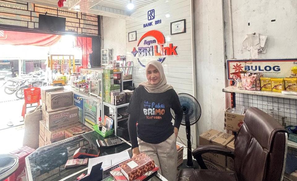 Tri Wenita, pemilik AgenBRILink Mulia Motor di Harapan Tani, Riau, menghadirkan layanan jemput bola untuk memudahkan transaksi perbankan warga desa.