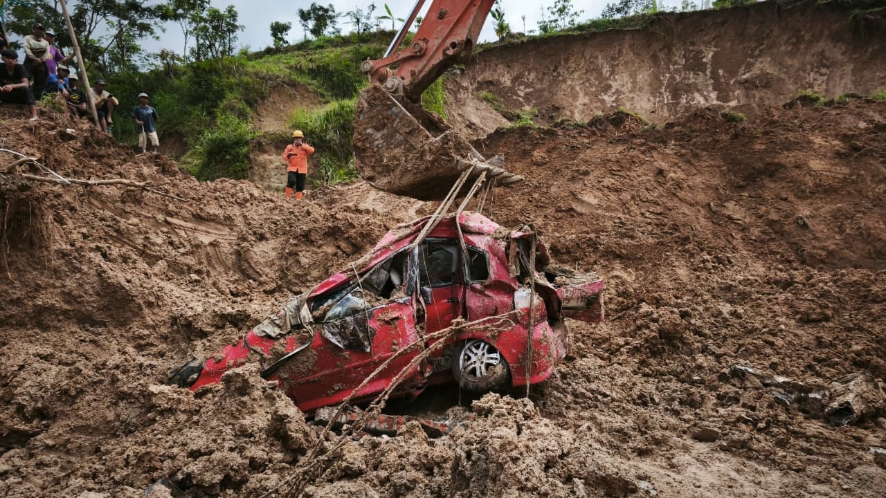 Petugas BPBD Ponorogo mengevakuasi Honda Jazz milik Jemirin yang tertimbun material longsor di Wagir Kidul, Pulung. SUGENG DWI N/RADAR PONOROGO
