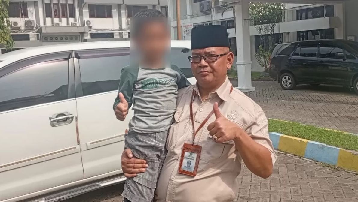 Petugas Dinas Sosial Gresik menggendong R, bocah yang sempat digadaikan.
