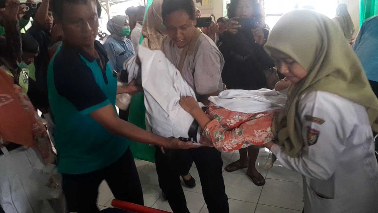 Seorang siswa SMPN 2 Kedunggalar Ngawi dibopong ke Puskesmas Gemarang usai keracunan menyantap MBG, Rabu (26/11). FOTO: ASEP SYAEFUL/RADAR NGAWI