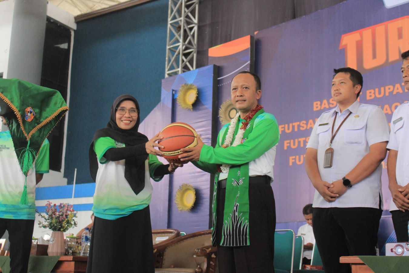RESMI DIBUKA: Staf Ahli Bidang Ekonomi Keuangan dan Pembangunan Pemkab Magetan Yok Sujarwadi memberi bola basket kepada Kepala SMAN 3 Magetan Riful Hamidah sebagai simbol dimulainya Turnamen Smaga Cup