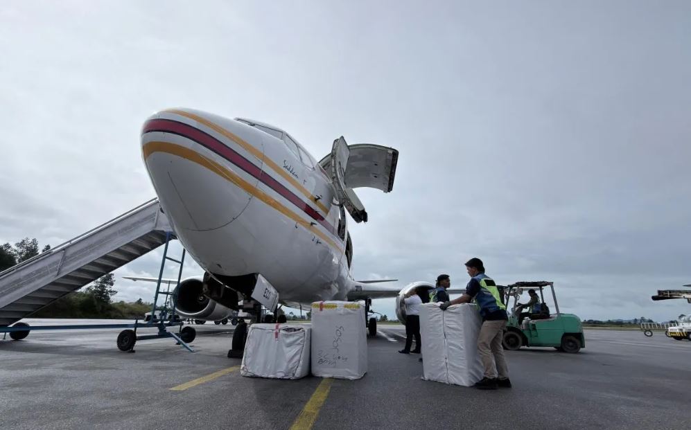Petugas menata bantuan logistik dari bagasi pesawat di Bandara Silangit, Tapanuli Utara, Sumatera Utara, Jumat (28/11/2025).