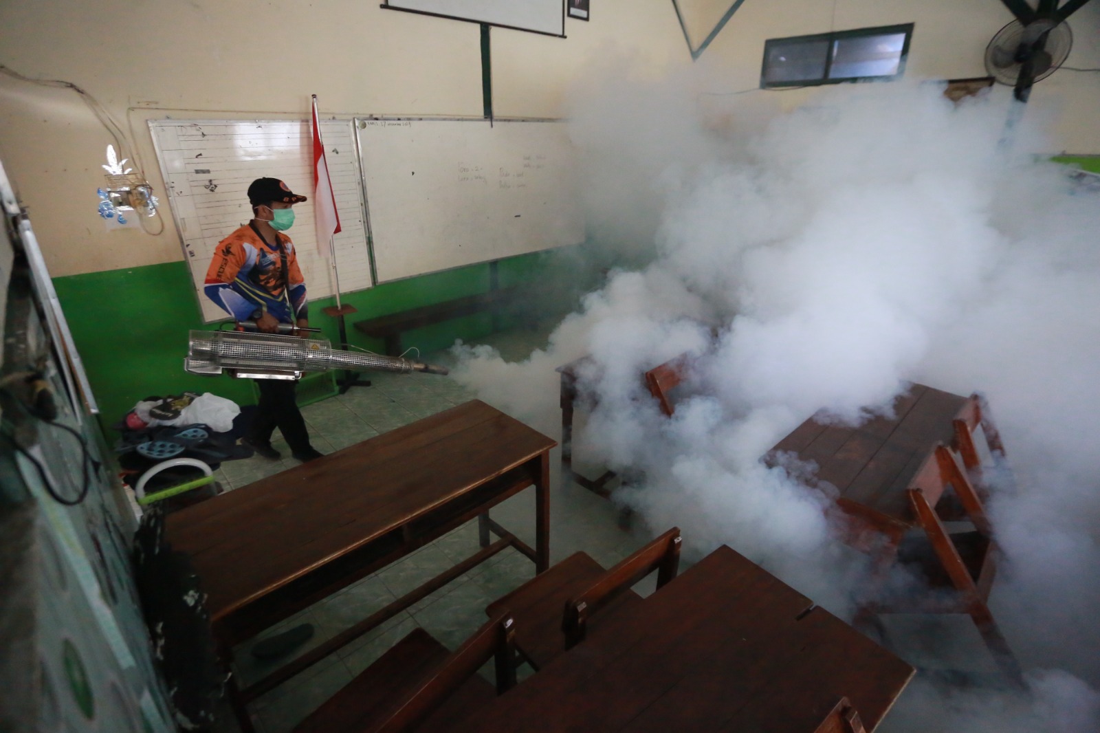 Petugas Puskesmas Sukosari melakukan fogging di SDN 01 Kartoharjo setelah dua siswanya terjangkit DBD. BAGAS BIMANTARA/RADAR MADIUN