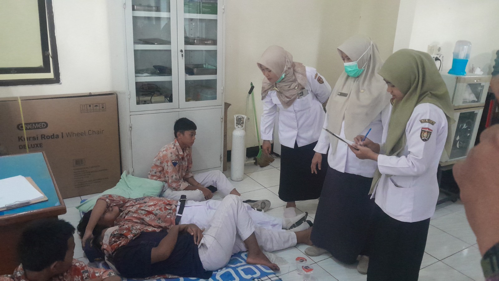 Petugas mengecek kondisi siswa di wilayah Kedunggalar selepas dugaan keracunan MBG. Satgas memastikan pengawasan dapur SPPG kini diperketat. ASEP SYAEFUL/RADAR NGAWI