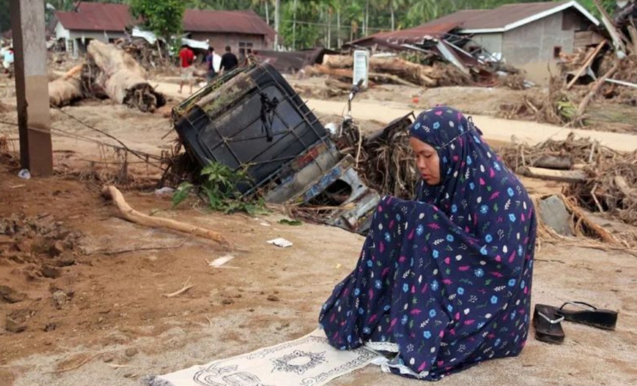 Warga salat di sekitar puing pemukiman usai terdampak banjir bandang di Tapanuli Selatan, Sumatera Utara, Minggu 30 November 2025.