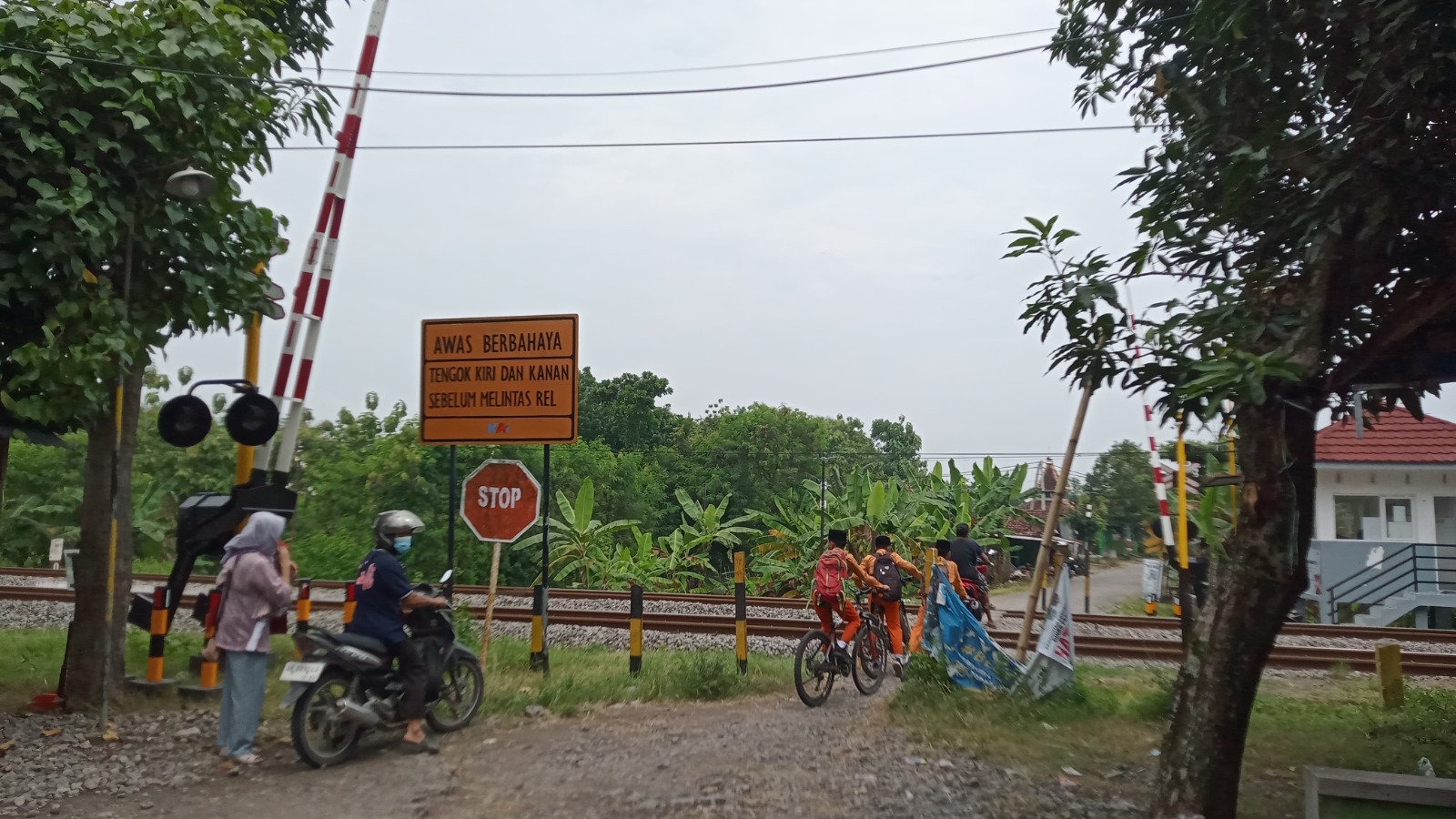 Perlintasan sebidang di Desa Jambangan, Paron, kini dilengkapi palang pintu otomatis dan pos jaga untuk meningkatkan keselamatan warga. ULUL RUBIYATUN/MAGANG/JAWA POS RADAR NGAWI