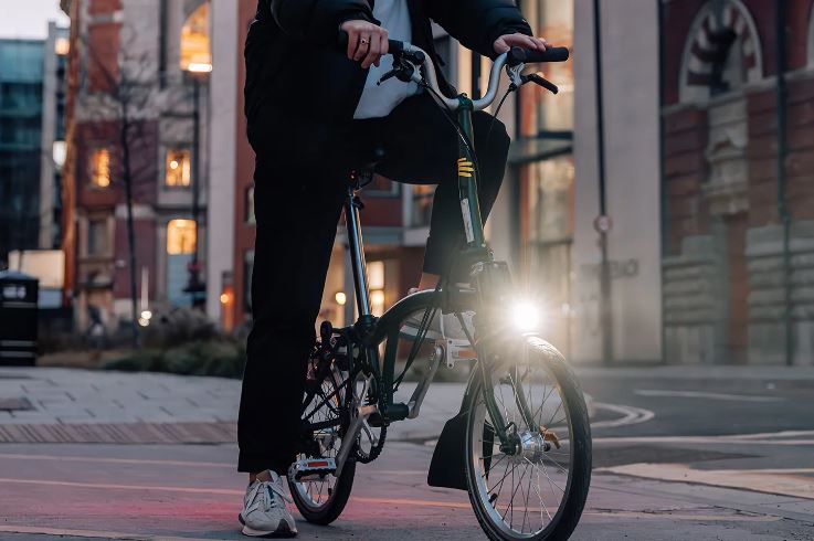 Ilustrasi sepeda lipat Brompton dengan lampu penerangan.