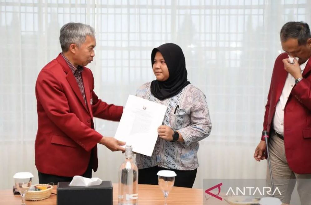 Rektor UPI Didi Sukyadi (kiri) saat memberikan SK pembebasan UKT kepada mahasiswi korban banjir bandang di Kota Bandung, Jawa Barat, Kamis (11/12/2025).