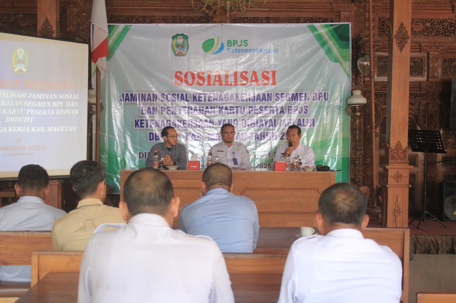 Disnaker Magetan menyerahkan kartu peserta BPJS Ketenagakerjaan bagi ribuan pekerja informal yang dibiayai DBHCHT 2025. AJI PUTRA/RADAR MAGETAN