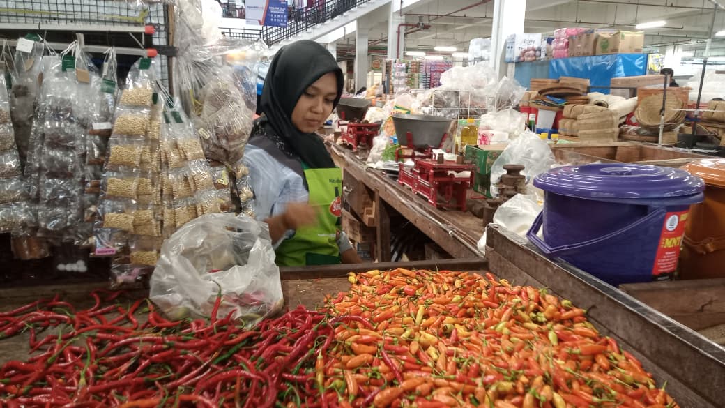 Pedagang Pasar Besar Ngawi merapikan dagangannya di tengah kenaikan harga berbagai komoditas pangan. ULUL RUBIYATUN/MAGANG/JAWA POS RADAR NGAWI