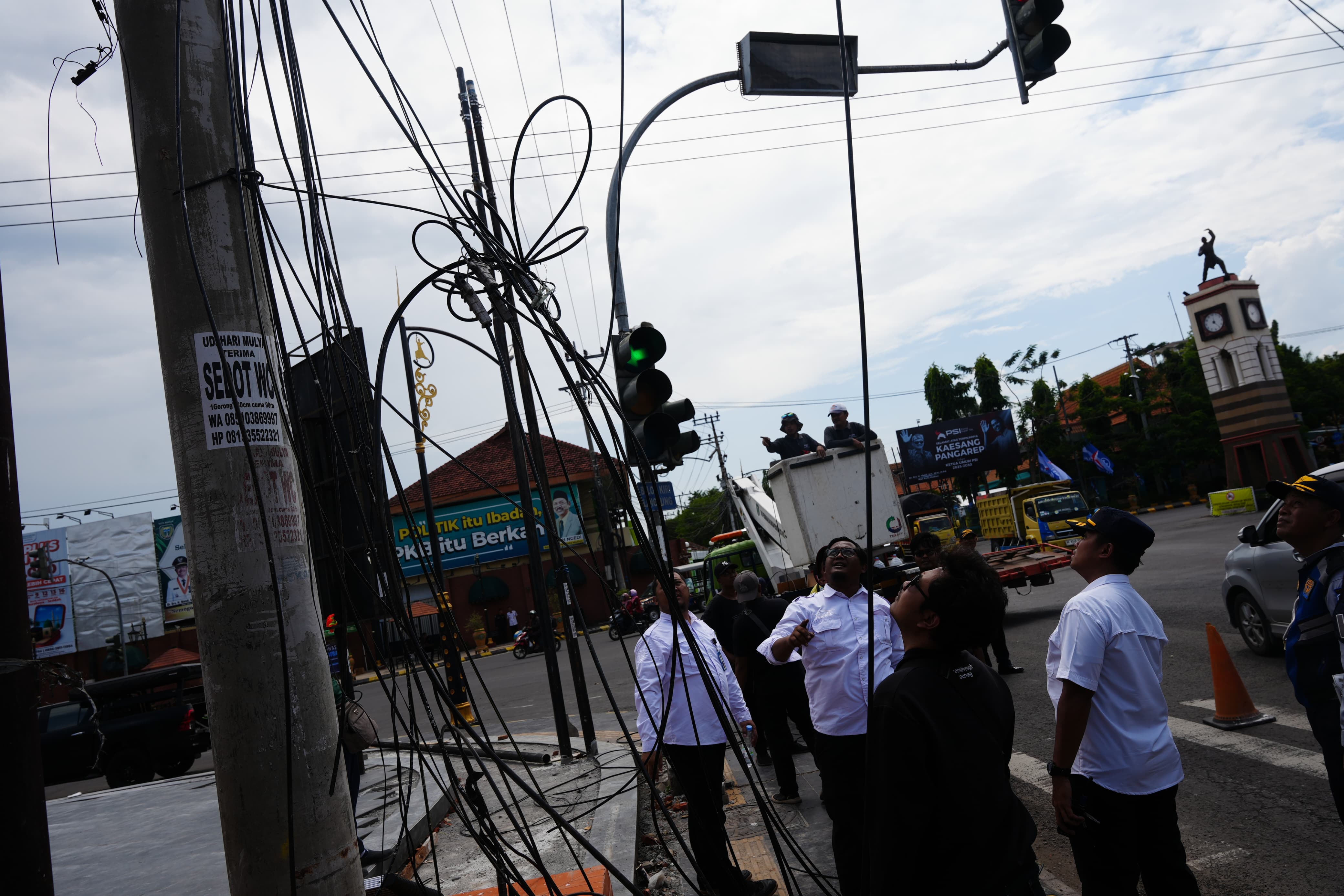 Diskominfo Kota Madiun bersama OPD terkait melepas kabel udara yang menggantung di kawasan Tugu Pendekar, Rabu (10/12). FOTO: DISKOMINFO KOTA MADIUN
