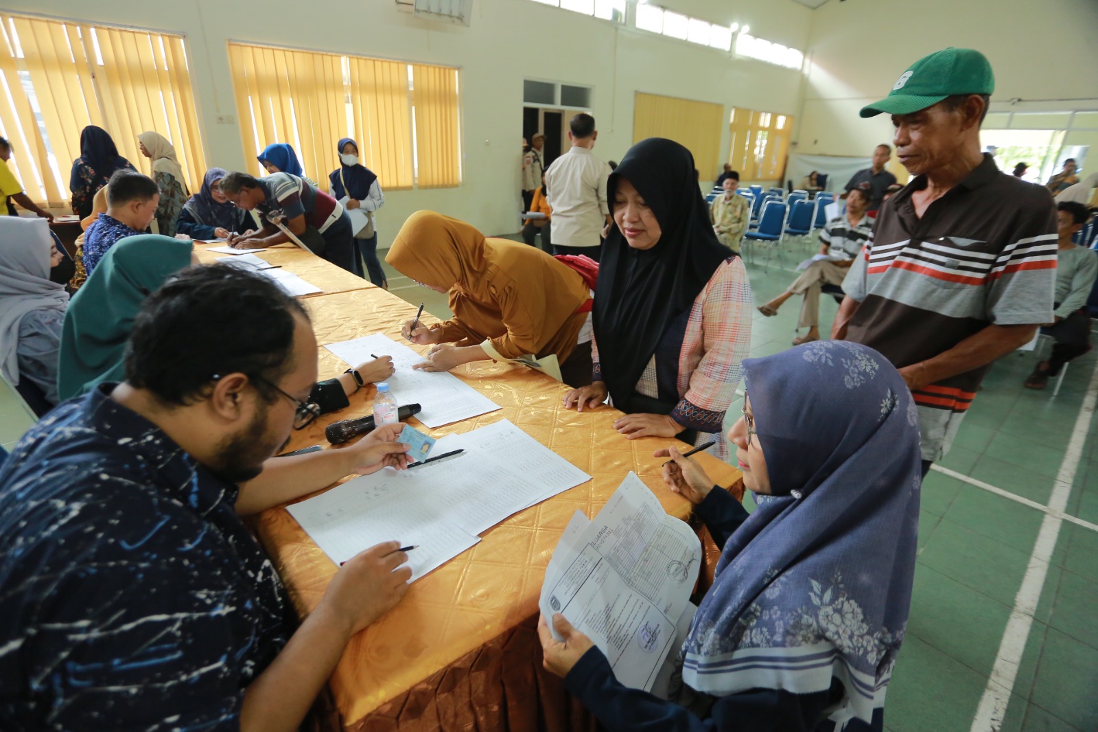Petugas menyalurkan bantuan BLTD dan DBHCHT kepada warga Kelurahan Kejuron, Kota Madiun, Selasa (9/12). BAGAS BIMANTARA/RADAR MADIUN