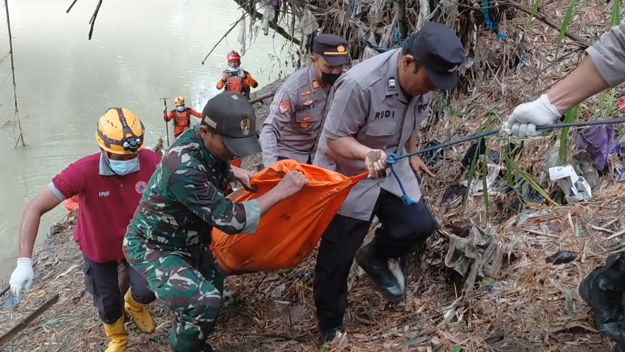 Petugas BPBD Magetan bersama TNI dan Polri mengevakuasi jasad seorang nenek yang ditemukan mengambang di Sungai Bengawan Madiun, Minggu (14/12). AJI PUTRA/RADAR MAGETAN