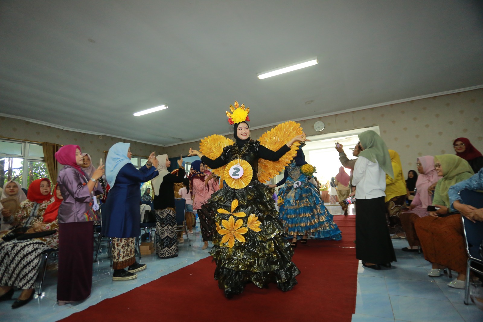 Para model mengenakan busana dari bahan daur ulang hasil kreasi ibu-ibu kelurahan di Kecamatan Kartoharjo dalam peragaan busana bertema lingkungan, Rabu (17/12). BAGAS BIMANTARA/JAWA POS RADAR MADIUN