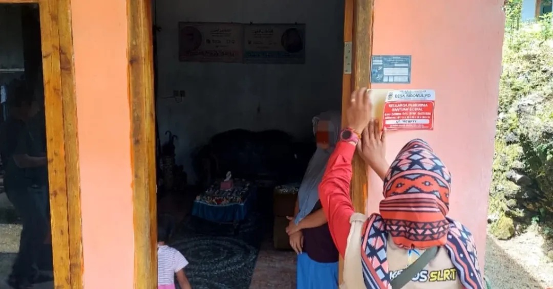 Petugas menempelkan stiker penerima bansos di rumah warga Desa Sidomulyo, Ngadirojo. PEMDES SIDOMULYO KEBONAGUNG UNTUK RADAR PACITAN