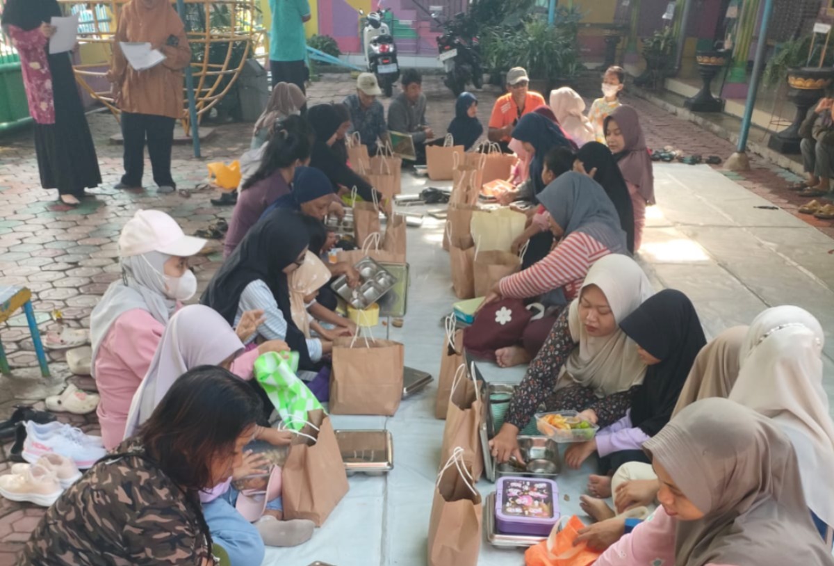 Para siswa dan wali murid TK ABA 3 Madiun mengambil paket Program Makan Bergizi Gratis (MBG) meski sekolah memasuki masa libur, Senin (22/12). FOTO: ISTIMEWA