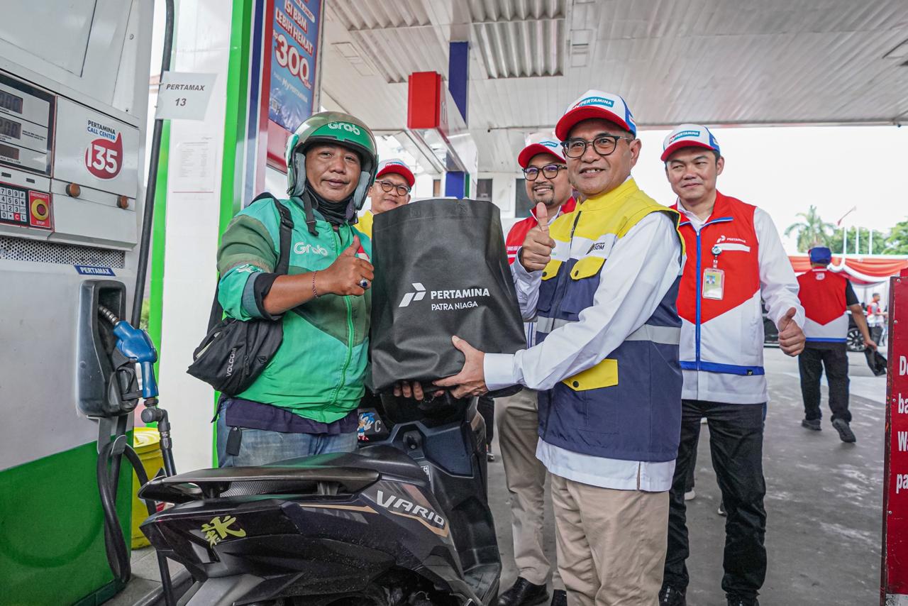 Pertamina Patra Niaga menyalurkan bantuan pendidikan bagi anak pengemudi ojek online serta layanan ganti oli gratis di SPBU COCO Jemursari, Surabaya, Rabu (24/12).