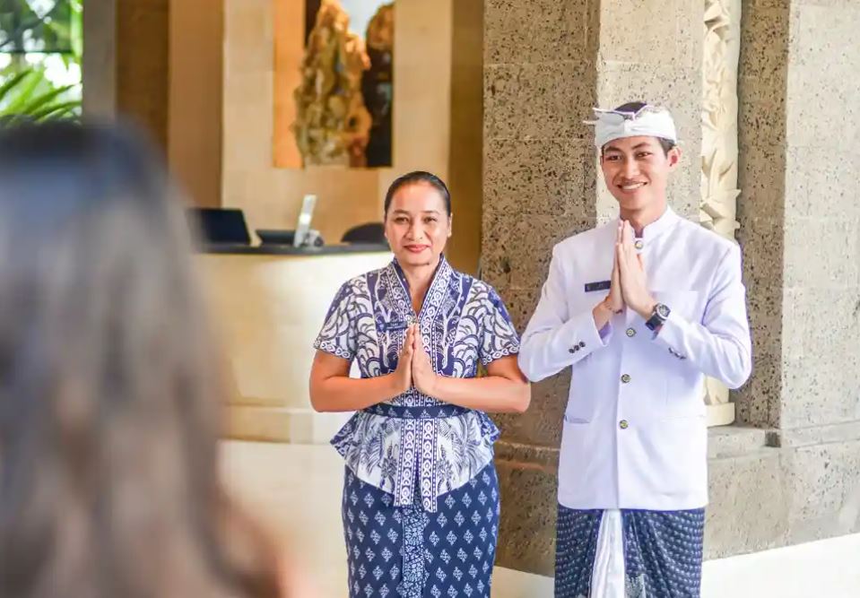 Ilustrasi pelayanan ramah pekerja hotel dan resort di Bali.