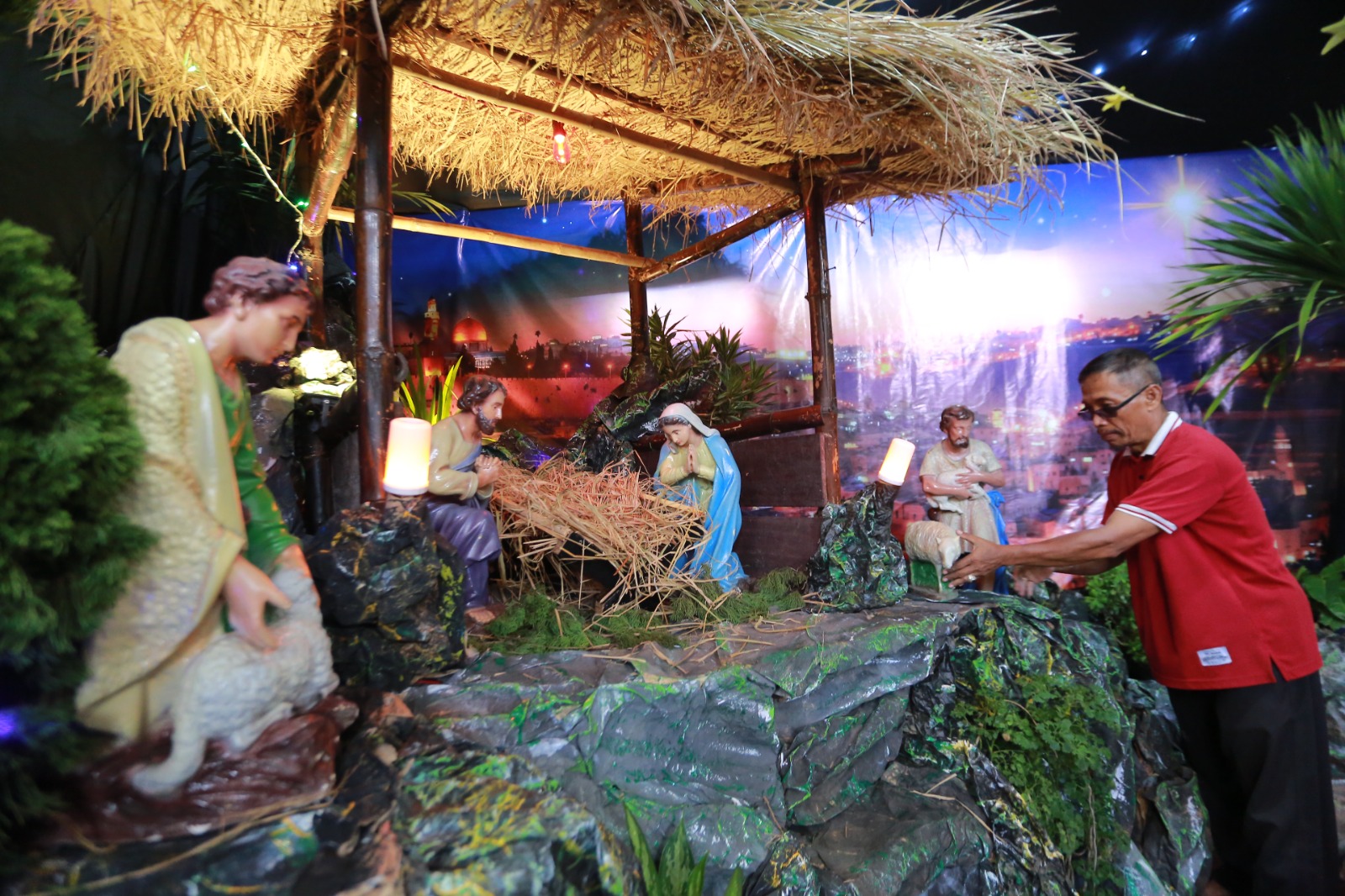 Andreas Nanang Koesharjono bersama tim menunjukkan Goa Natal 2025 yang dibuat dari barang bekas di Paroki Santo Cornelius Madiun, Rabu (24/12). (BAGAS BIMANTARA/JAWA POS RADAR MADIUN)