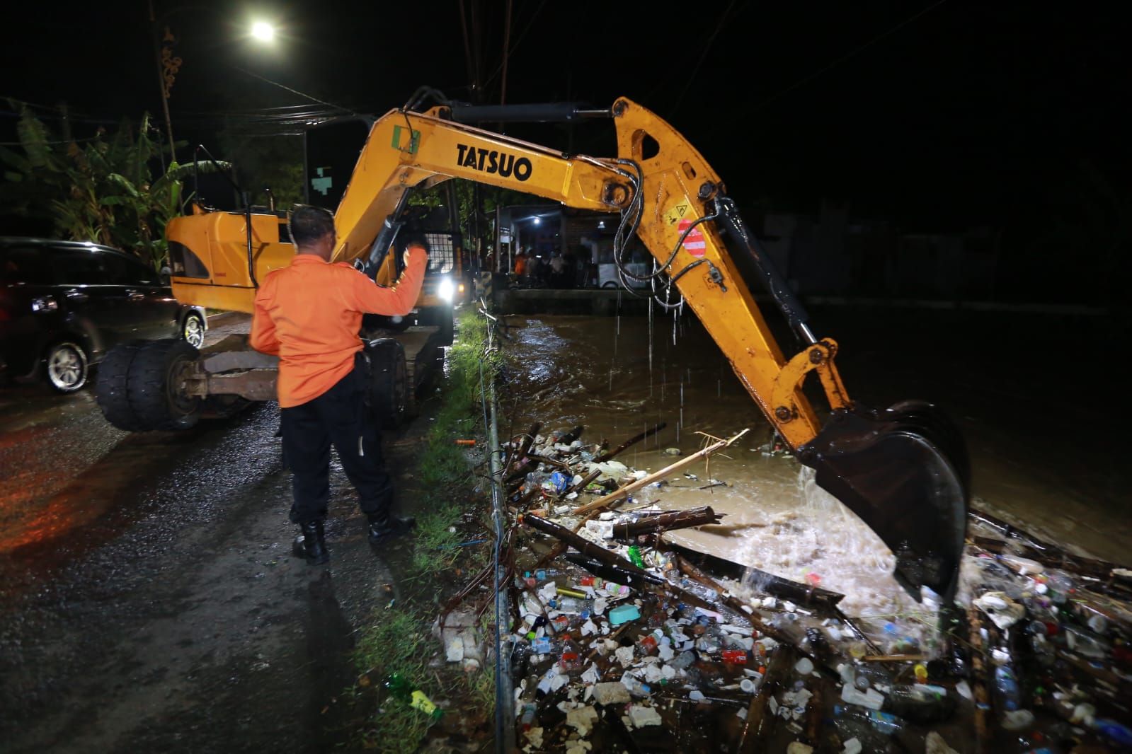 Petugas BPBD Kota Madiun bersama instansi terkait membersihkan sampah dan bambu yang menyangkut di aliran Sungai Bok Malang, Kartoharjo, Kamis (25/12) malam. BAGAS BIMANTARA/RADAR MADIUN