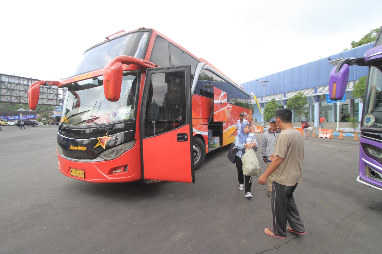 LENGANG: Penumpang turun dari bus antarkota antarprovinsi di Terminal Maospati, Magetan, yang masih terpantau landai hingga H+1 Natal. AJI PUTRA/RADAR MAGETAN