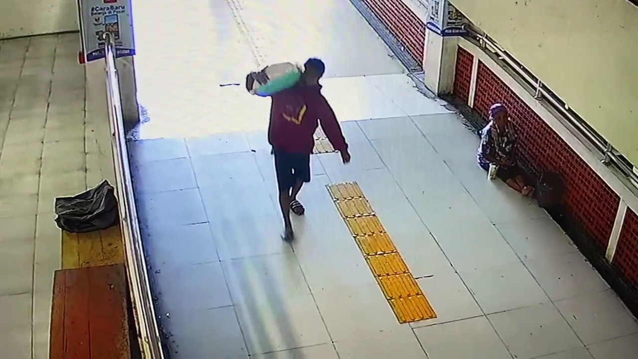 PANJANG TANGAN: Tangkapan layar CCTV memperlihatkan pria menyamar sebagai kuli panggul membawa kabur karung beras milik pedagang Pasar Besar Ngawi. FOTO: ISTIMEWA