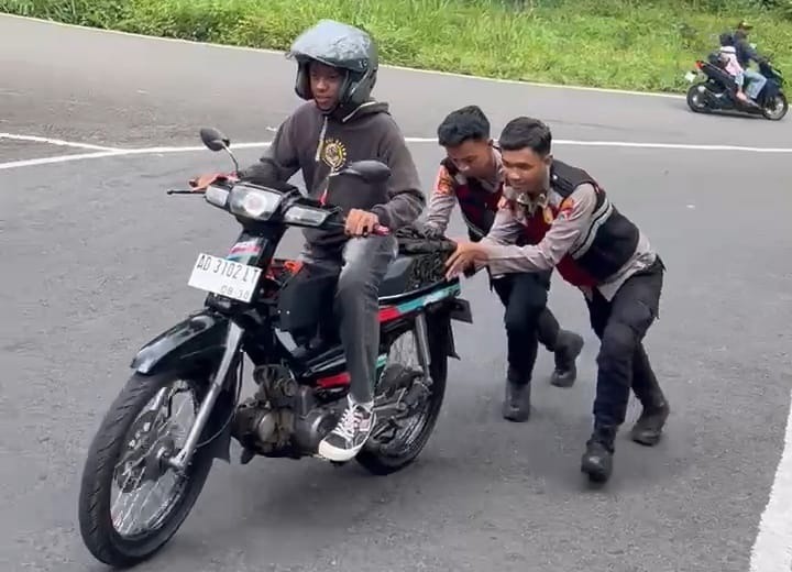 RESPONSIF: Personel Tim Drogba Polres Magetan sigap membantu kendaraan wisatawan yang kesulitan menanjak di jalur Sarangan selama libur Nataru. FOTO: ISTIMEWA