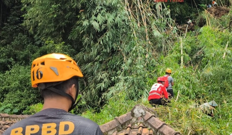 BENCANA: Petugas BPBD Magetan dibantu warga mengevakuasi rumpun bambu tumbang yang menimpa rumah penduduk di Desa Plumpung, Plaosan, Sabtu (27/12). FOTO: BPBD MAGETAN