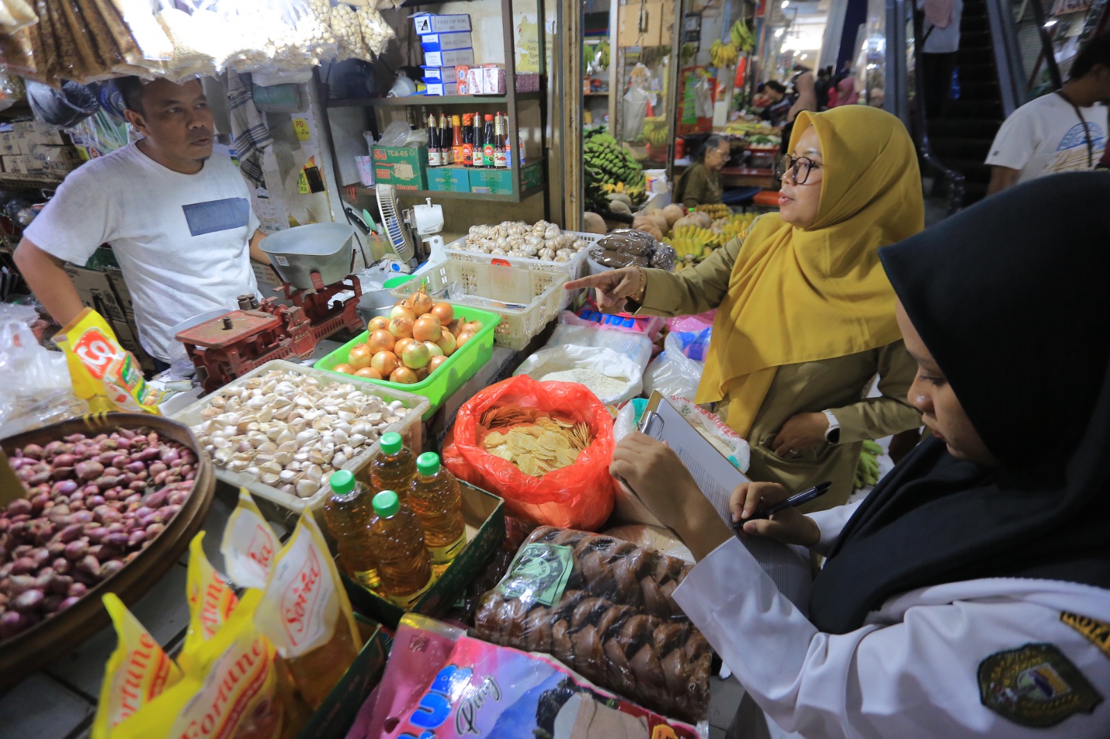 STABIL: Petugas Dinas Perdagangan Kota Madiun memantau harga kebutuhan pokok di Pasar Besar Madiun menjelang pergantian Tahun Baru 2026, Senin (29/12). BAGAS BIMANTARA/RADAR MADIUN