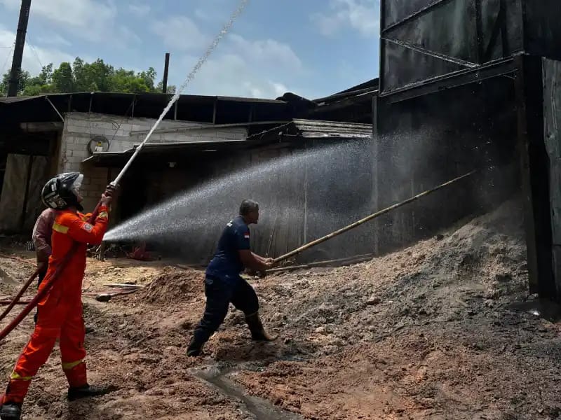 KEBAKARAN: Petugas pemadam kebakaran memadamkan api di gudang penyimpanan serbuk kayu pabrik TOP Donorojo, Pacitan, Selasa (30/12). FOTO: ISTIMEWA