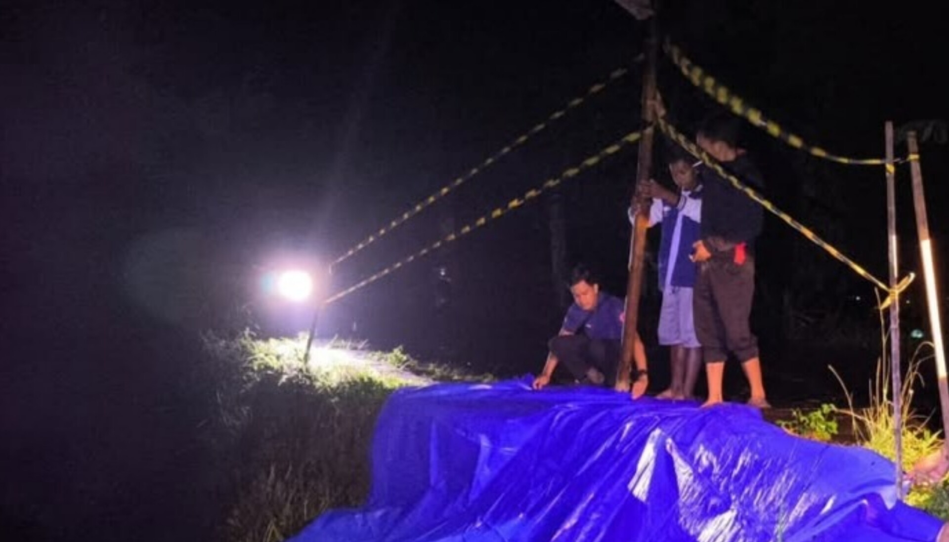 ANTISIPASI LONGSOR: Petugas BPBD Magetan memasang terpal dan garis peringatan di lokasi longsor bahu jalan Kelurahan Alastuwo, Kecamatan Poncol. FOTO: ISTIMEWA
