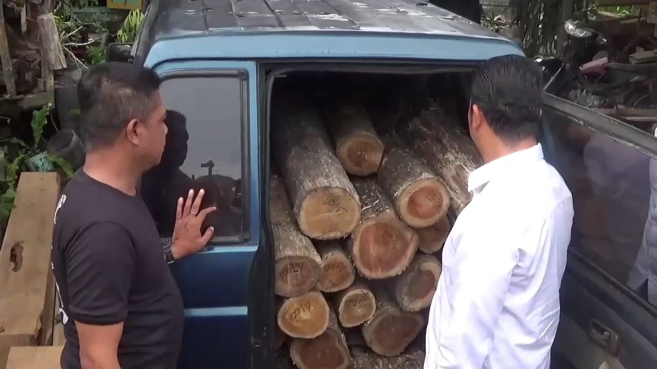 PERAMBAH HUTAN: Polisi mengamankan dua pelaku ilegal logging di Ngawi beserta ratusan batang kayu jati hasil pembalakan liar saat penindakan, kemarin (6/1). FOTO: ISTIMEWA